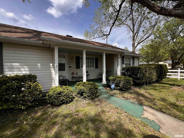 view of front of house featuring a porch and fence