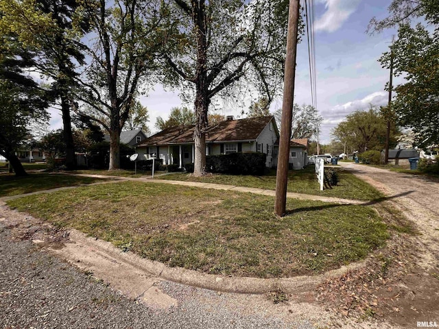 single story home with driveway, a chimney, and a front lawn