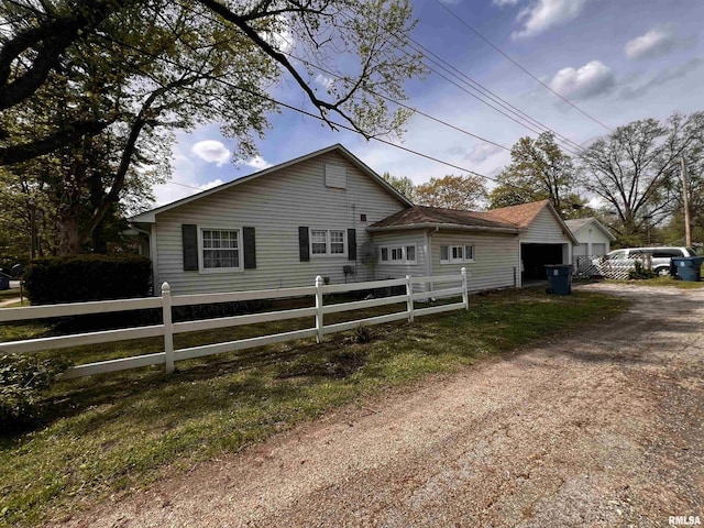 view of property exterior featuring fence and a garage