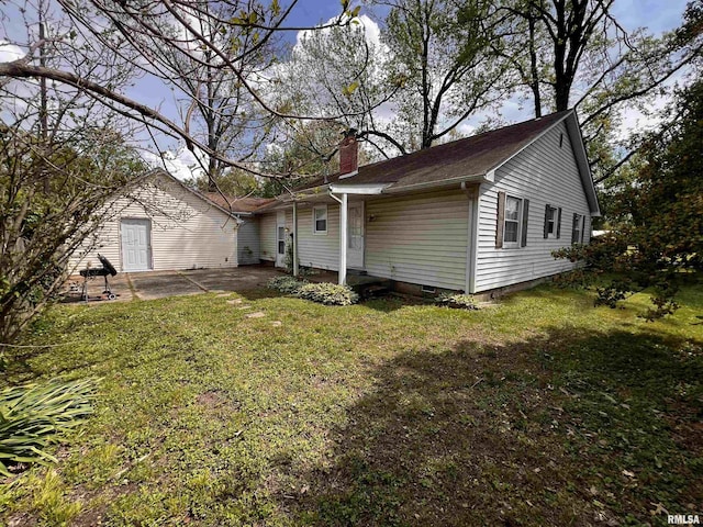 rear view of property with a patio, crawl space, a yard, and a chimney