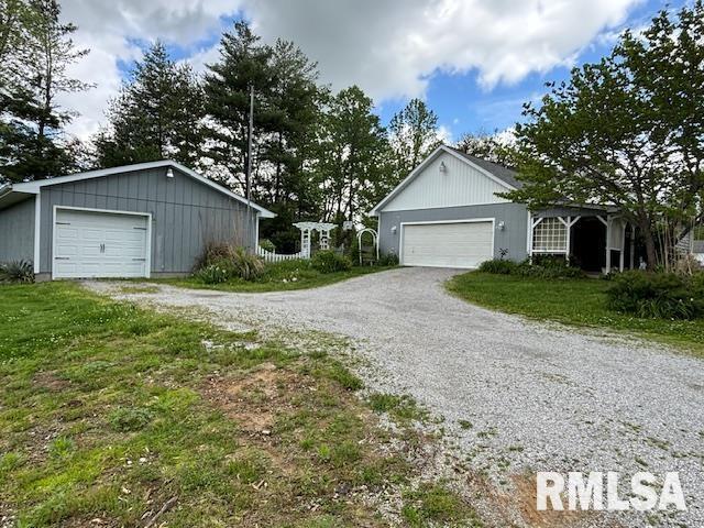 view of front of property with gravel driveway and a front yard
