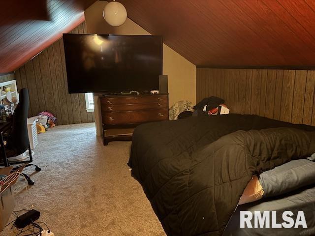 bedroom with wooden walls, wood ceiling, vaulted ceiling, and carpet flooring