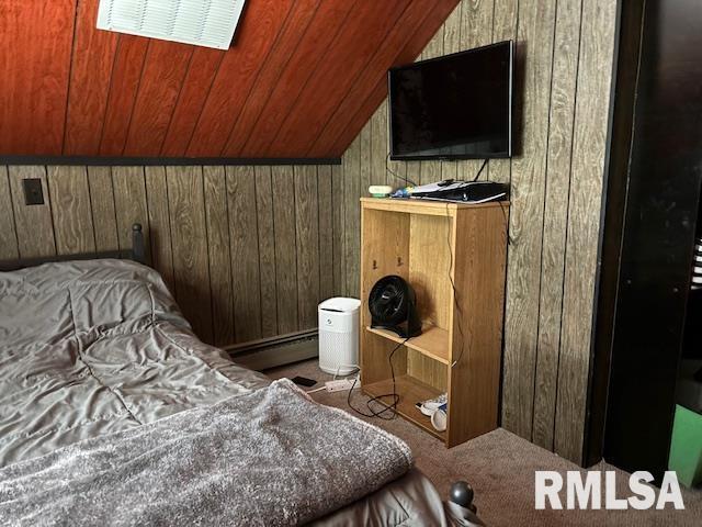 bedroom with vaulted ceiling, wooden ceiling, a baseboard radiator, wooden walls, and carpet flooring