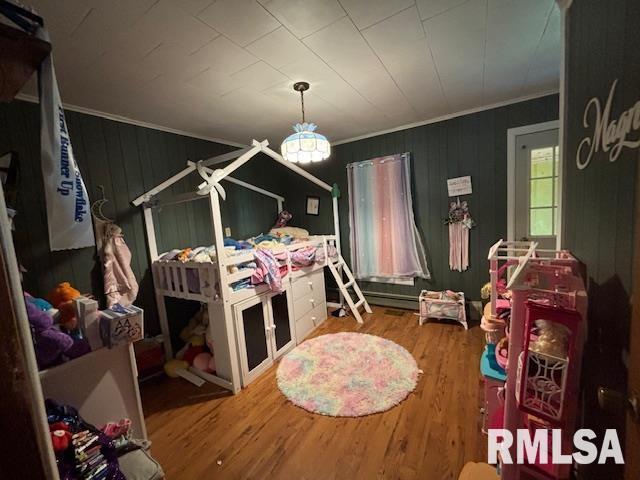 bedroom with crown molding and wood finished floors