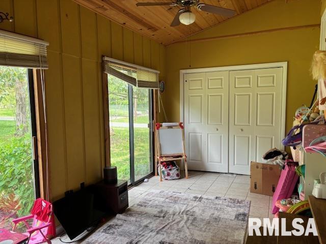 bedroom with wood ceiling, multiple windows, vaulted ceiling, and light tile patterned flooring