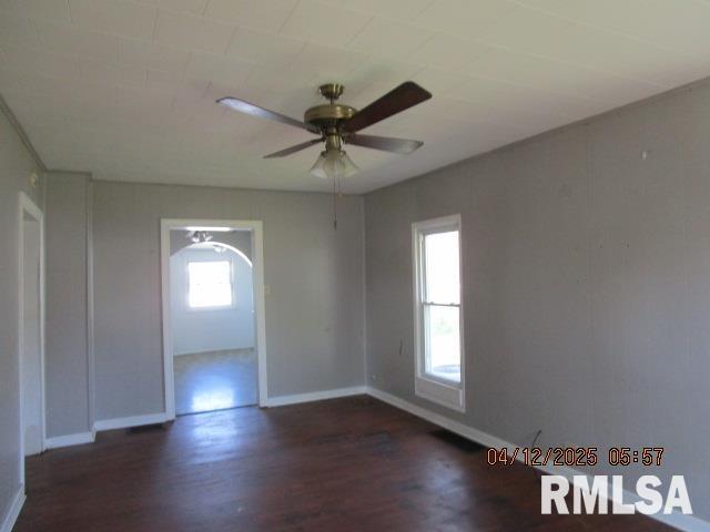 spare room with baseboards, ceiling fan, and wood finished floors