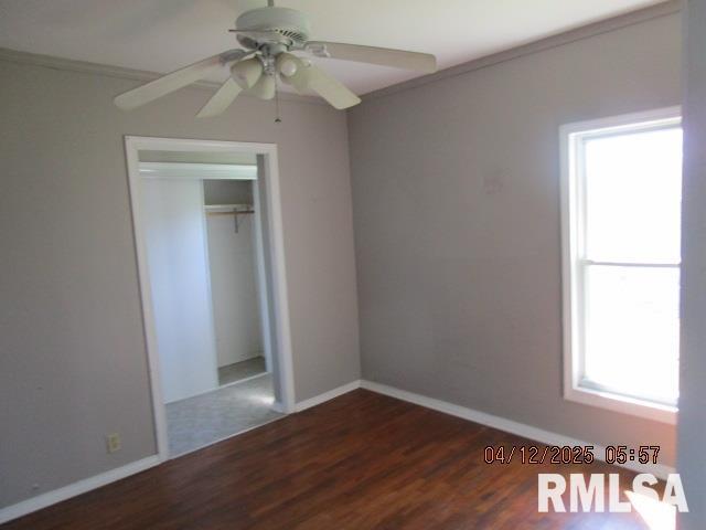 unfurnished bedroom with baseboards, ornamental molding, a ceiling fan, and wood finished floors