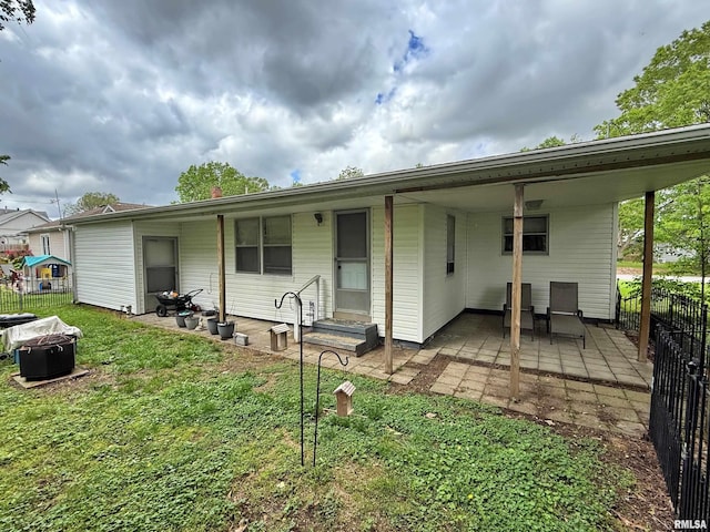 rear view of house with fence and a lawn