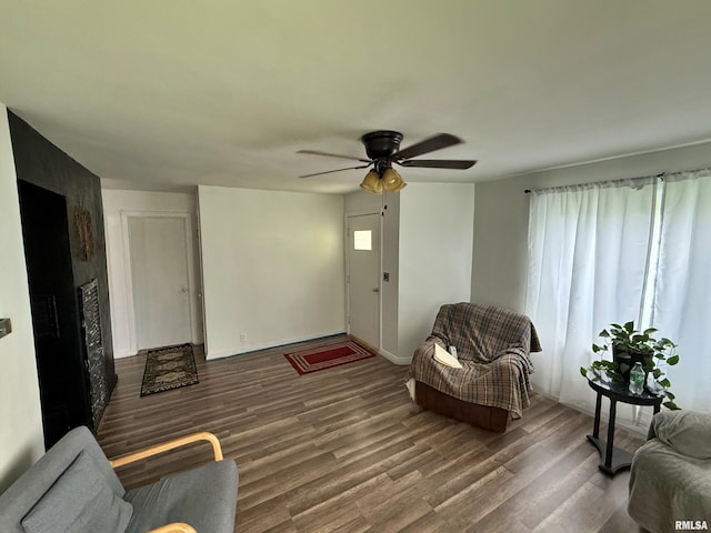 living room with baseboards, ceiling fan, wood finished floors, and a wealth of natural light