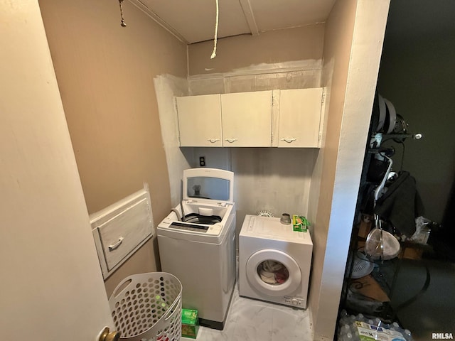 laundry area featuring cabinet space, separate washer and dryer, and marble finish floor
