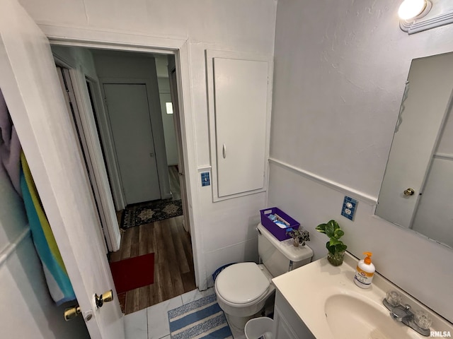 bathroom featuring toilet, wood finished floors, and vanity