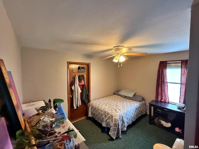 bedroom featuring a ceiling fan, a closet, and dark colored carpet
