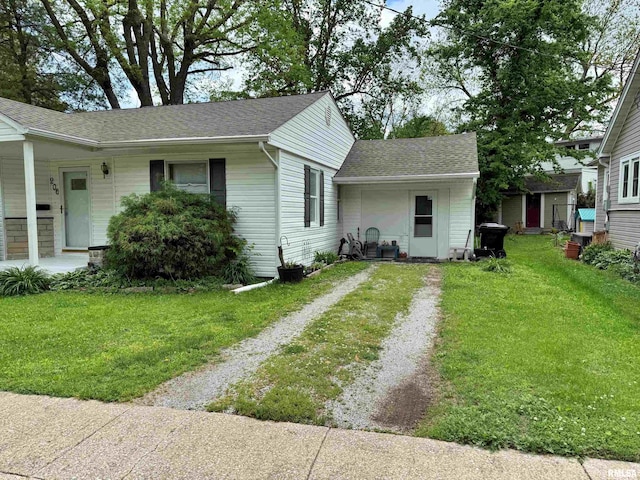 view of front of property with a shingled roof, a front lawn, driveway, and covered porch