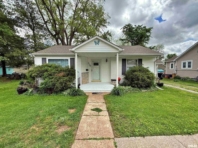 bungalow-style house featuring a porch, roof with shingles, and a front yard