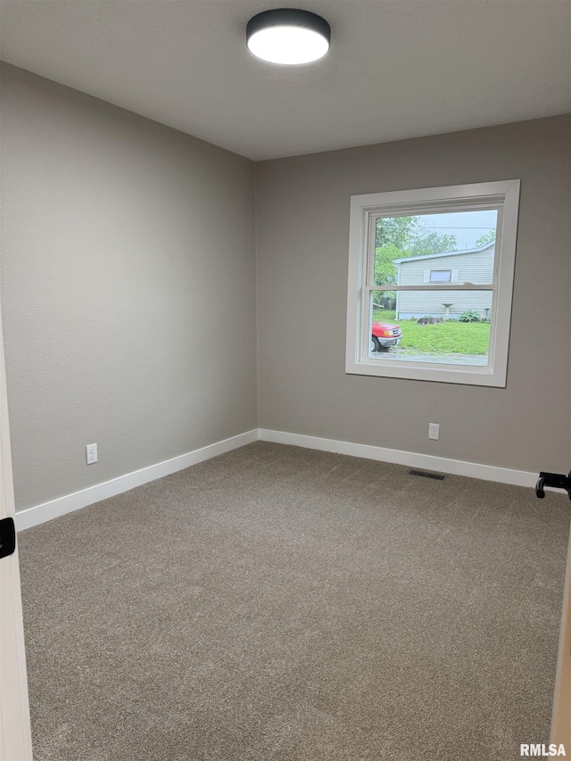 carpeted empty room with baseboards and visible vents