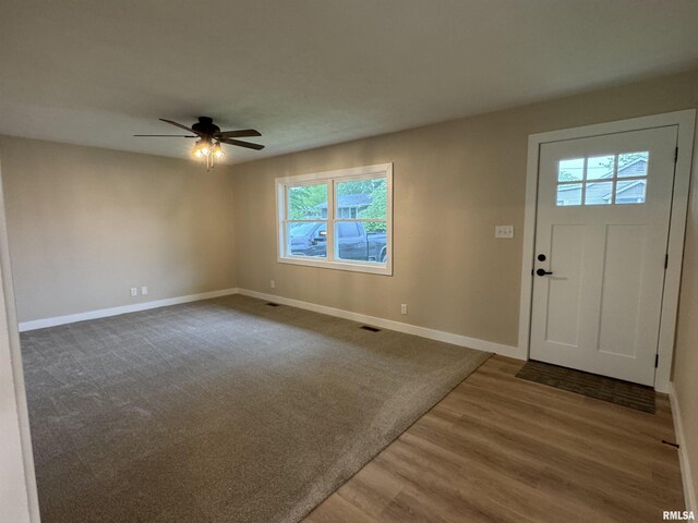 entrance foyer featuring baseboards, ceiling fan, wood finished floors, and visible vents