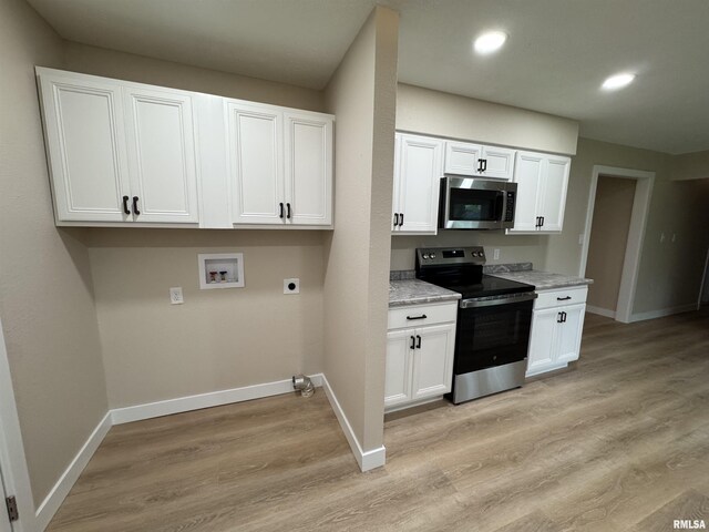 kitchen with white cabinetry, baseboards, appliances with stainless steel finishes, and light wood finished floors