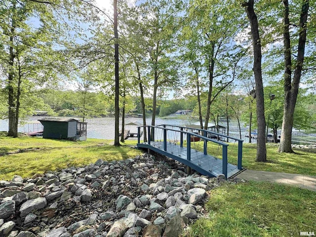 view of yard featuring an outdoor structure, a water view, and a shed
