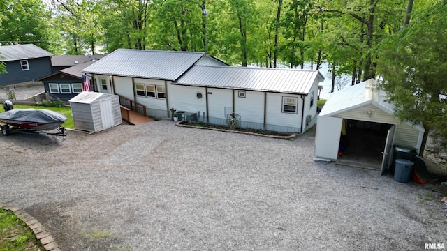 ranch-style home with an outdoor structure, driveway, and metal roof