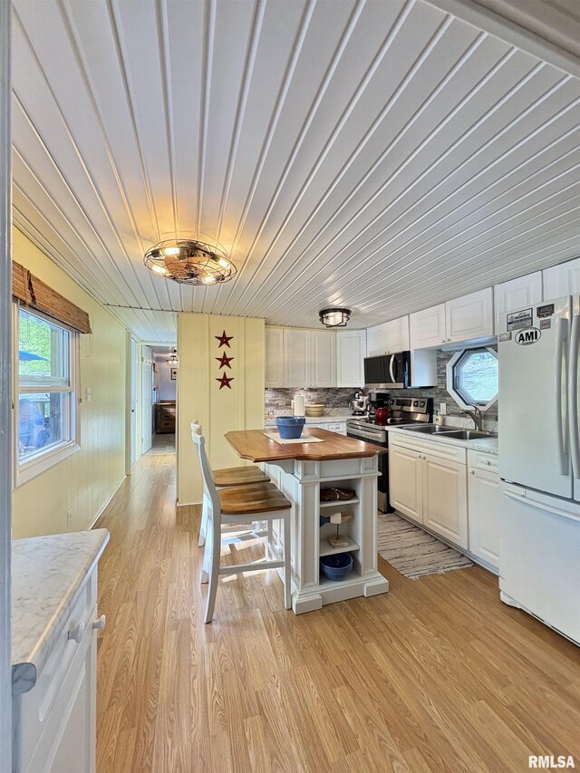 kitchen with white cabinets, open shelves, stainless steel appliances, and butcher block countertops