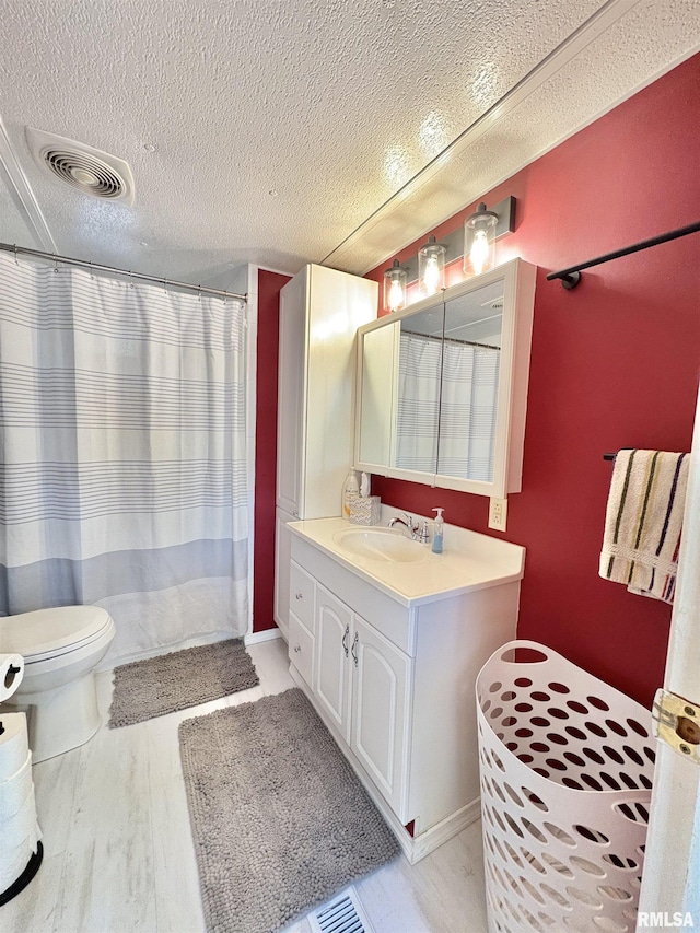 full bathroom featuring visible vents, a textured ceiling, a shower with curtain, and vanity