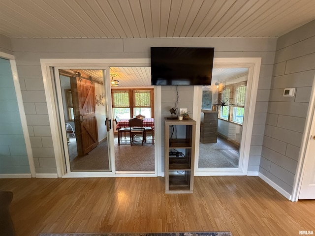 interior space featuring wood ceiling, wood walls, a wealth of natural light, and wood finished floors
