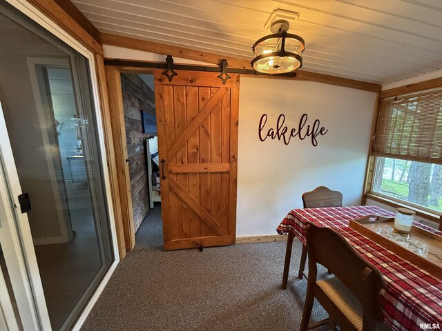 carpeted dining room featuring wooden ceiling and a barn door
