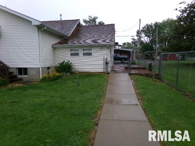 217 Trammel Rd, Carrier Mills, IL 62917 - exterior space with fence, a shingled roof, and a lawn