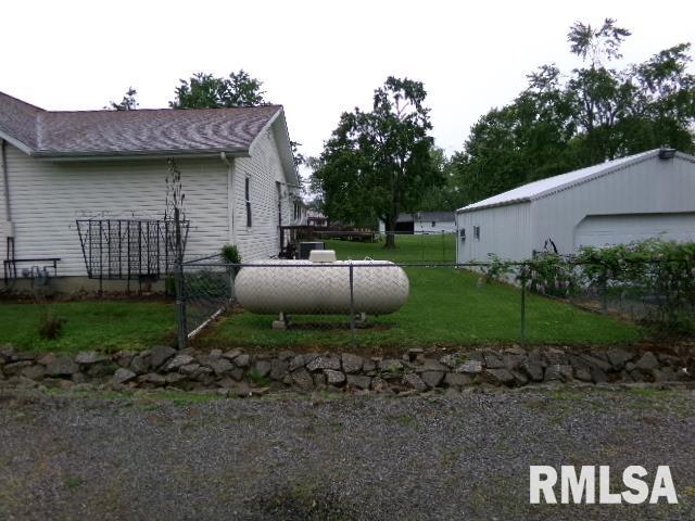 217 Trammel Rd, Carrier Mills, IL 62917 - view of side of home featuring a lawn, fence, and a garage