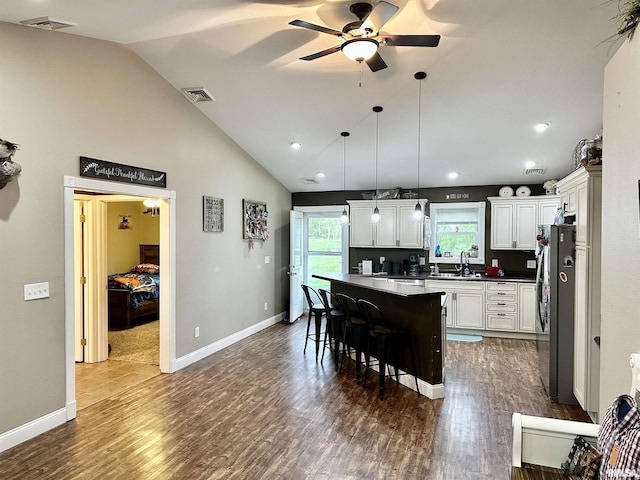 1821 Zion Hill Rd, Centralia, IL 62801 - kitchen featuring freestanding refrigerator, ceiling fan, a kitchen breakfast bar, a kitchen island, and dark wood-style flooring