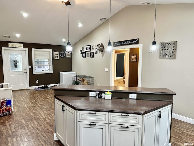 1821 Zion Hill Rd, Centralia, IL 62801 - kitchen featuring dark countertops, lofted ceiling, dark wood finished floors, white cabinets, and a center island