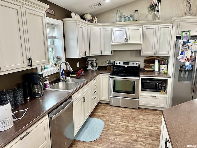 1821 Zion Hill Rd, Centralia, IL 62801 - kitchen featuring stainless steel appliances, lofted ceiling, light wood-type flooring, and dark countertops