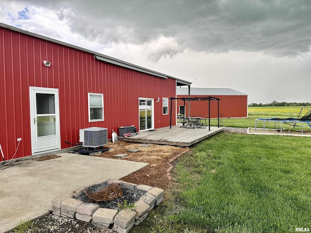 1821 Zion Hill Rd, Centralia, IL 62801 - rear view of house featuring a wooden deck, a yard, an outdoor fire pit, and a trampoline