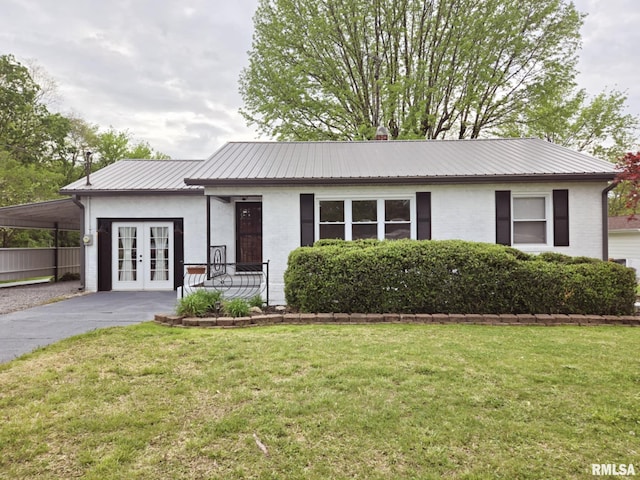 single story home with driveway, french doors, metal roof, and a front lawn