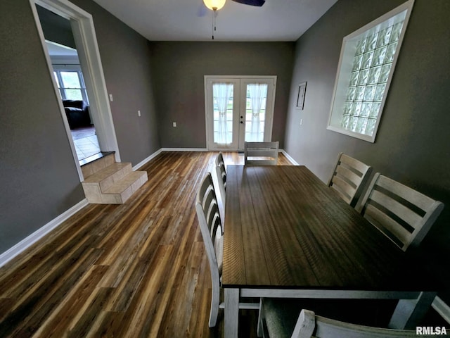 unfurnished dining area featuring french doors, baseboards, a ceiling fan, and wood finished floors