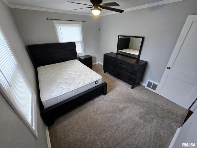 bedroom with a ceiling fan, light colored carpet, crown molding, visible vents, and baseboards