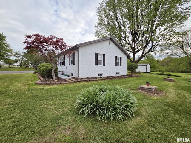 view of side of property featuring a yard, brick siding, an outbuilding, and a storage unit