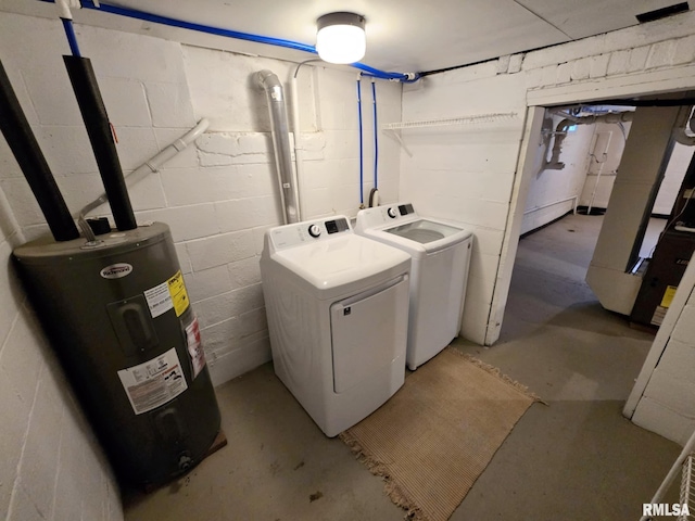 laundry room with concrete block wall, separate washer and dryer, laundry area, and electric water heater