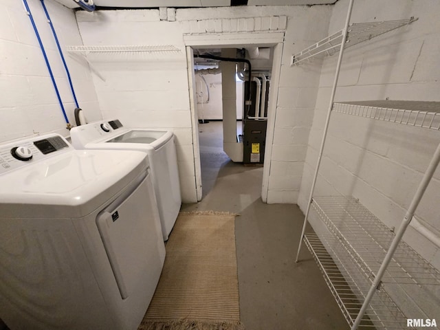laundry room with washer and dryer, concrete block wall, laundry area, and heating unit
