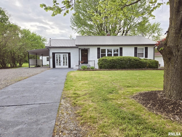 ranch-style home featuring concrete driveway, a front yard, stucco siding, french doors, and metal roof