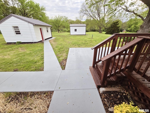view of yard featuring a wooden deck and an outbuilding