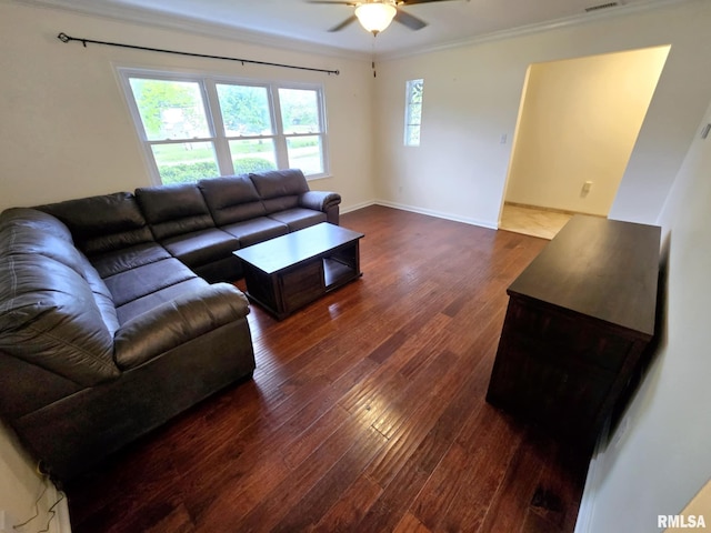 living room featuring crown molding, visible vents, baseboards, dark wood-style floors, and a ceiling fan