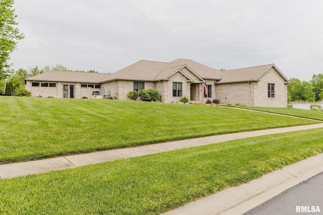 single story home with brick siding, a shingled roof, and a front yard