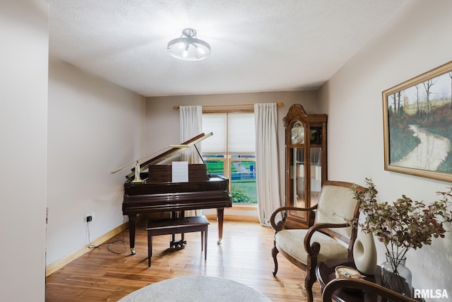 sitting room featuring baseboards and wood finished floors