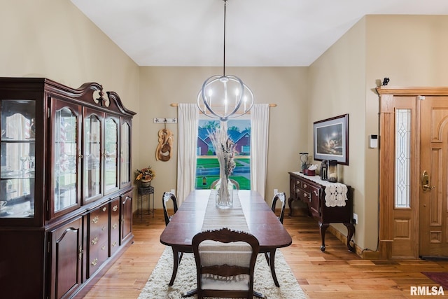 dining room with light wood-style floors, baseboards, and an inviting chandelier