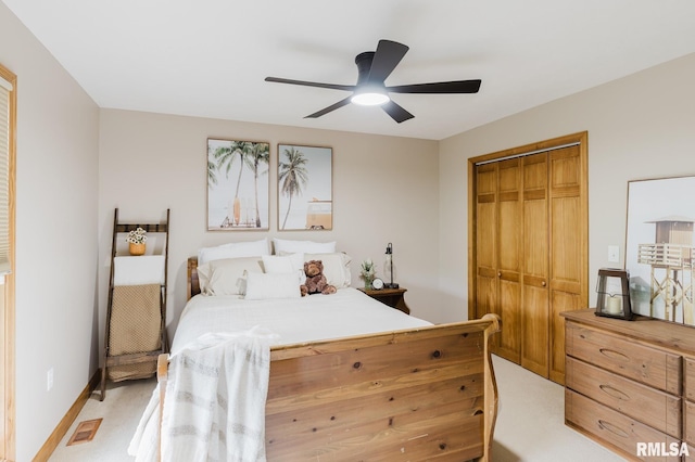 bedroom featuring ceiling fan, light carpet, baseboards, visible vents, and a closet