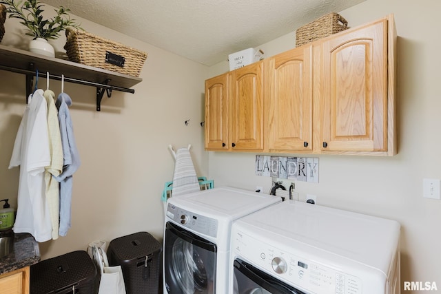 clothes washing area featuring cabinet space, a textured ceiling, and washing machine and clothes dryer