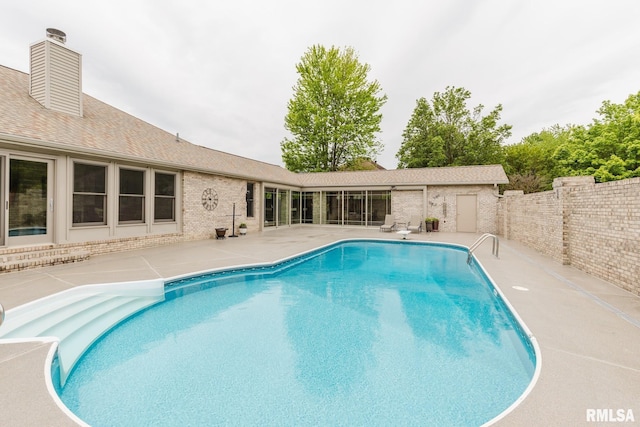 pool with a fenced backyard and a patio area