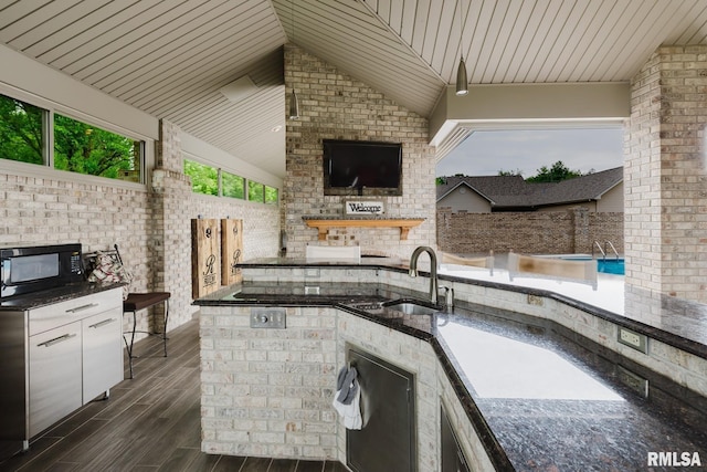 view of patio / terrace with a sink, an outdoor kitchen, and fence
