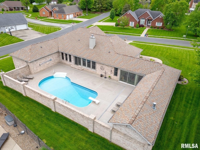 view of pool with fence, a patio area, a diving board, a yard, and a residential view